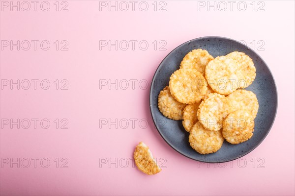 Traditional japanese rice chips cookies with honey and soy sauce on a pastel pink background. Top view, flat lay, copy space