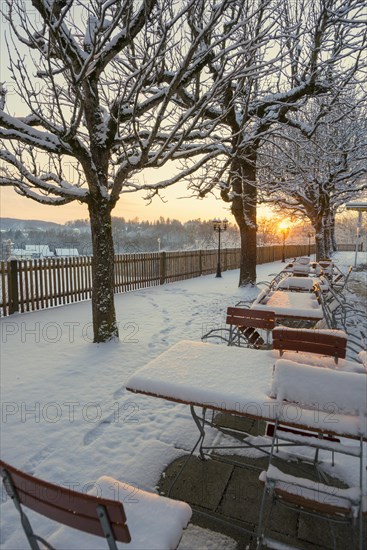 Snow-covered beer garden in winter, sunset, Andechs Monastery, Fuenfseenland, Pfaffenwinkel, Upper Bavaria, Bavaria, Germany, Europe