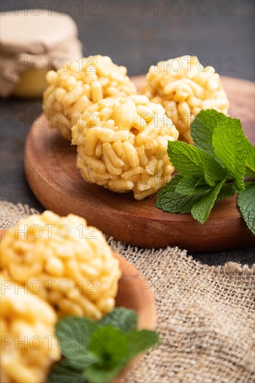 Traditional Tatar candy chak-chak made of dough and honey with cup of coffee on a black concrete background and linen textile. Side view, close up, selective focus