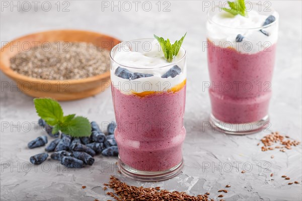 Smoothie with honeysuckle, linen and chia in a glass on gray concrete background. side view, close up, selective focus