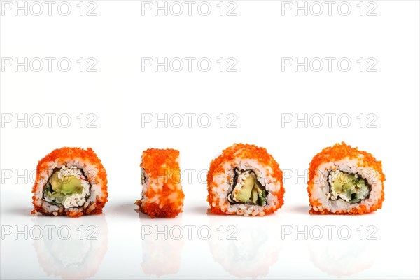Four Japanese maki sushi rolls in a row with flying fish roe, avocado, and cucumber isolated on white background. Side view, close up