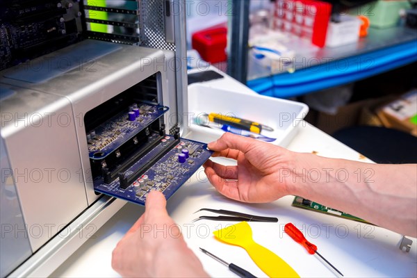 Technician opening the back part of a computer to repair it in a workshop