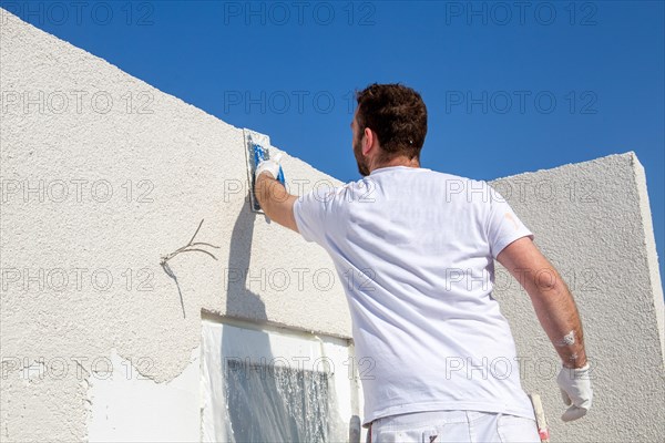 Plasterer plasters the facade of a new building