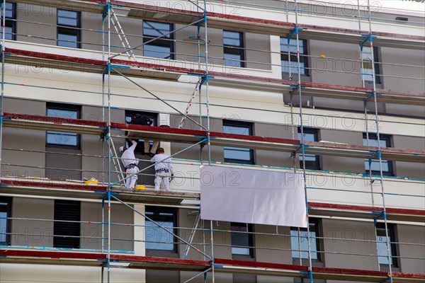 Painter painting the facade of a new apartment building