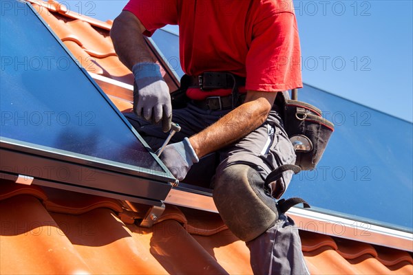 Installation of solar collectors for solar thermal energy. The company Hanschke Solarmontagen installs solar panels on a newly built apartment block in Mutterstadt (Palatinate)