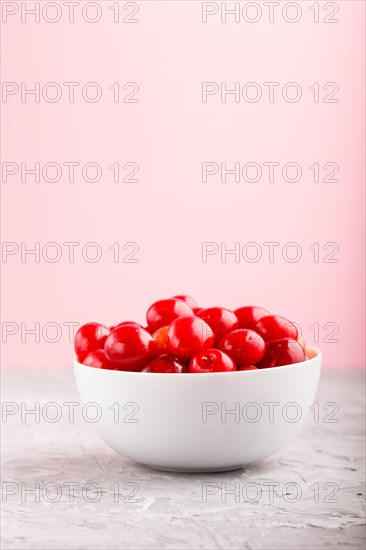 Fresh red sweet cherry in white bowl on gray and pink background. side view, close up, selective focus, copy space