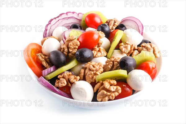 Salad with cherry tomatoes, mozzarella cheese, black olives, kiwi, and walnuts isolated on white background. close up