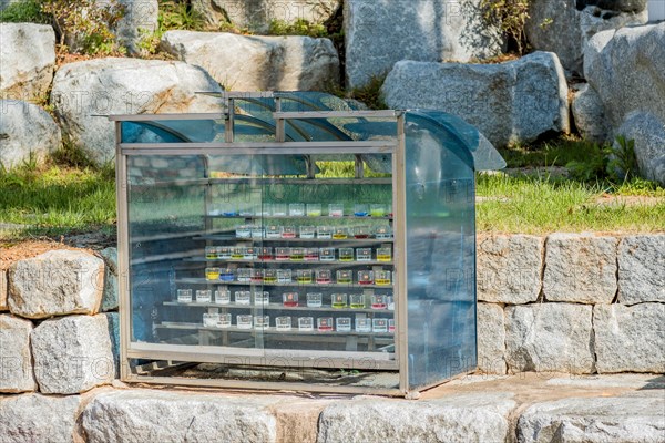 Closeup of prayer candles in glass cabinet on stone ledge in church countryside park in South Korea