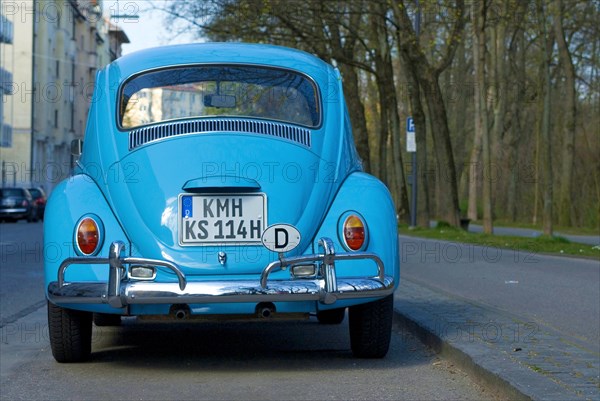 Rear of a light blue VW Volkswagen Beetle parked at the roadside, letters KMH are altered and do not exist in Germany