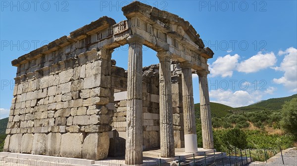 Ancient columned building in front of a blue sky with decorative clouds, Mausoleum, Heroon, Archaeological site, Ancient Messene, Capital of Messinia, Messini, Peloponnese, Greece, Europe