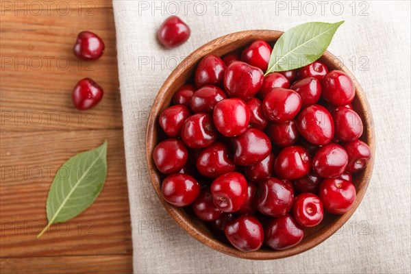 Fresh red sweet cherry in wooden bowl on wooden background. top view, flat lay, close up