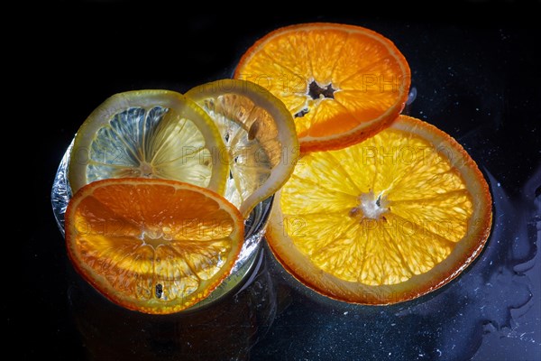 Transparent slices of fresh oranges and lemons on the glass with ice