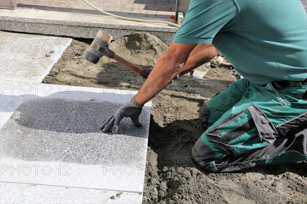 Worker lays paving stones