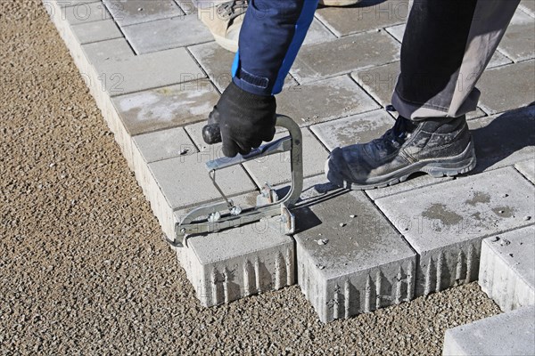 Workers lay paving stones