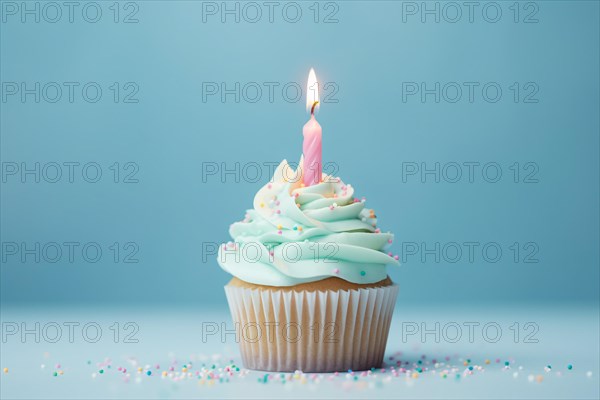 Single cupcake with frosting, sugar sprinkles and birthday candle on blue background. KI generiert, generiert AI generated