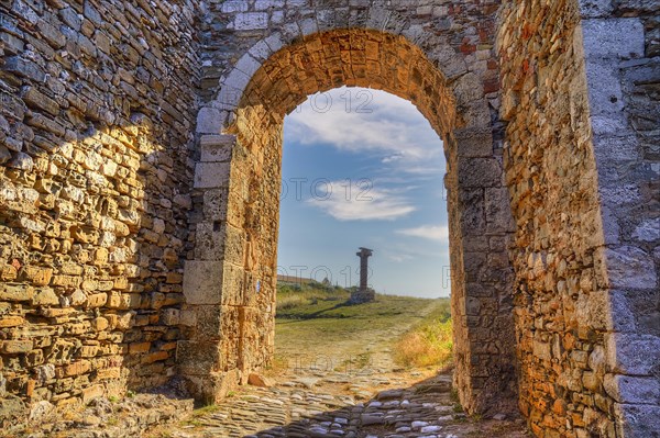 Stone arch with view of a path and ancient column in the background, sea fortress Methoni, Peloponnese, Greece, Europe