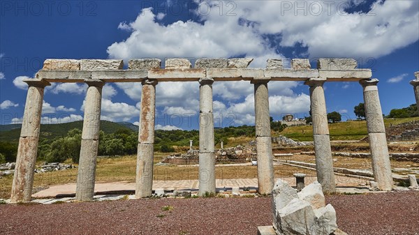 Ruins of ancient columns under a blue sky with fluffy clouds, Stoa of the Agora, Archaeological site, Ancient Messene, Capital of Messinia, Messini, Peloponnese, Greece, Europe