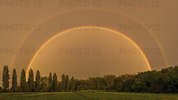 A complete and double rainbow after a thunderstorm over a cultivated landscape in the Palatinate