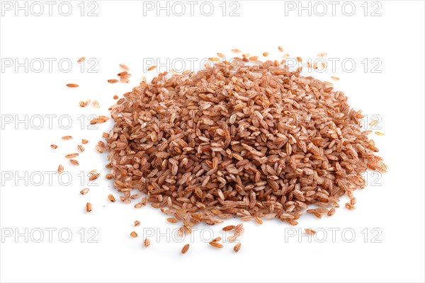 Heap of unpolished brown rice isolated on white background. Side view, flat lay, close up, macro