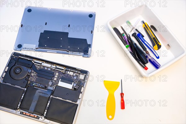 Top view of a white workshop table with tools and digital tablet to repair