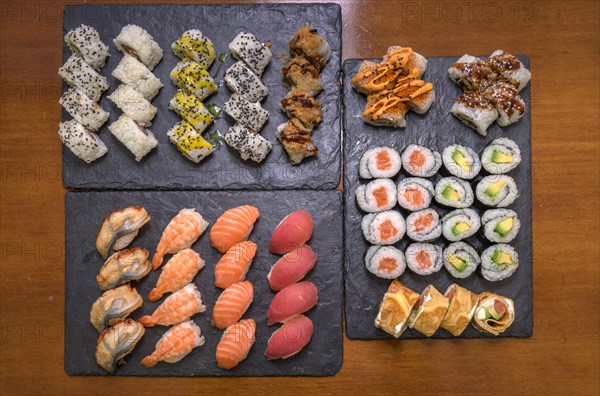 A selection of various sushi including rolls and nigiri on two slate serving platters, Majorca, Balearic Islands, Spain, Europe