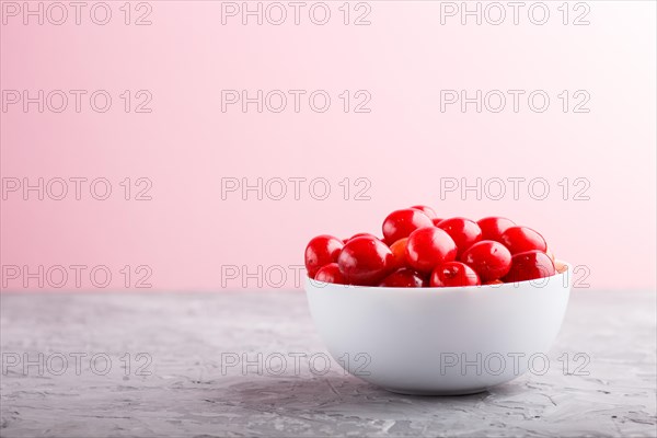 Fresh red sweet cherry in white bowl on gray and pink background. side view, close up, selective focus, copy space