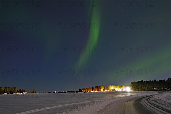 Northern lights over fields and a road, winter landscape, Lulea, Sweden, Europe