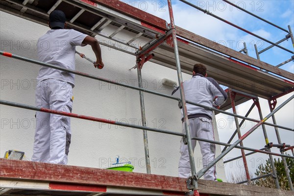 Painter painting the facade of a new residential building