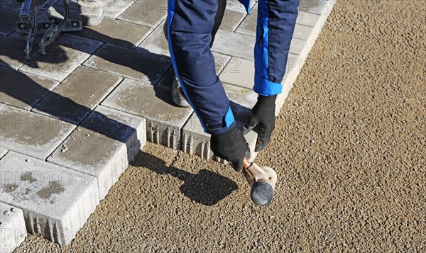 Workers lay paving stones