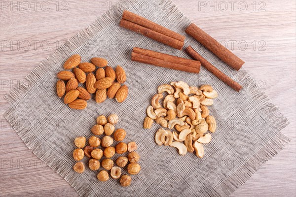 Cinnamon, almonds, hazelnuts, cashew on a linen napkin. Still life. Closeup
