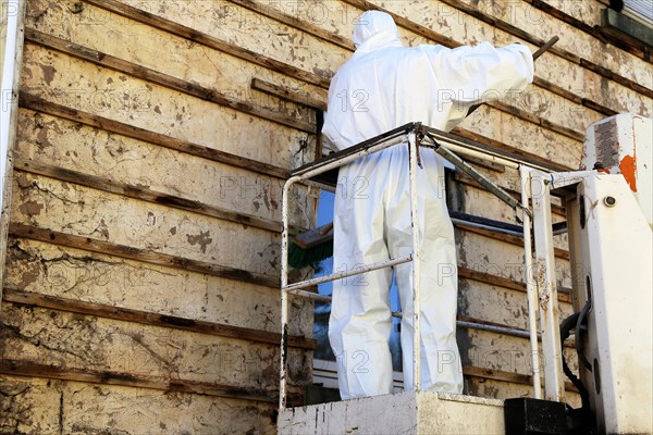 Professional asbestos removal by workers in protective suits