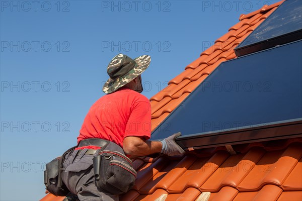 Installation of solar collectors for solar thermal energy. The company Hanschke Solarmontagen installs solar panels on a newly built apartment block in Mutterstadt (Palatinate)