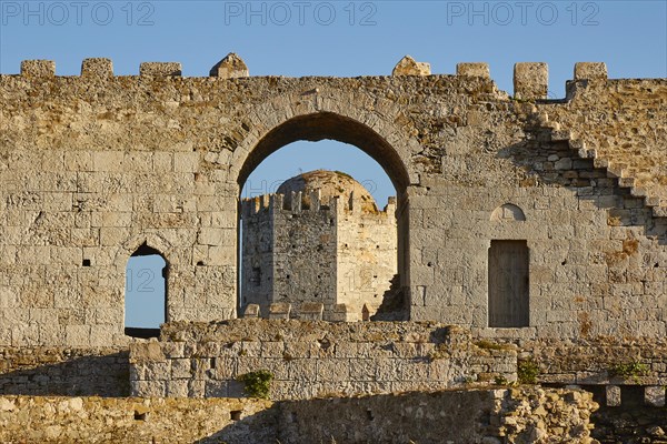 Part of an old castle wall with arches and window openings under a clear blue sky, sea fortress Methoni, Peloponnese, Greece, Europe