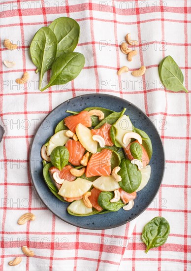 Fresh salmon with pineapple, spinach and cashew on a gray concrete background. Top view, flat lay, linen tablecloth