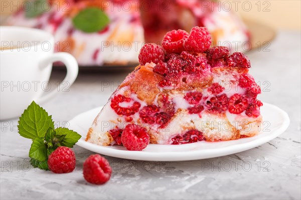Homemade jelly cake with milk, cookies and raspberry on a gray concrete background with cup of coffee. side view. close up
