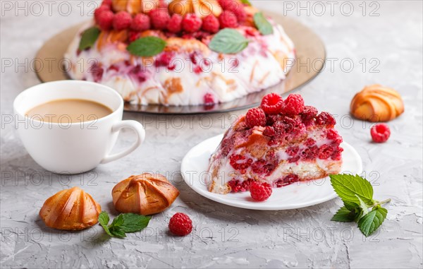 Homemade jelly cake with milk, cookies and raspberry on a gray concrete background with cup of coffee. side view. close up