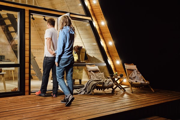 A couple returns to tiny log cabin late at night after a walk outdoors