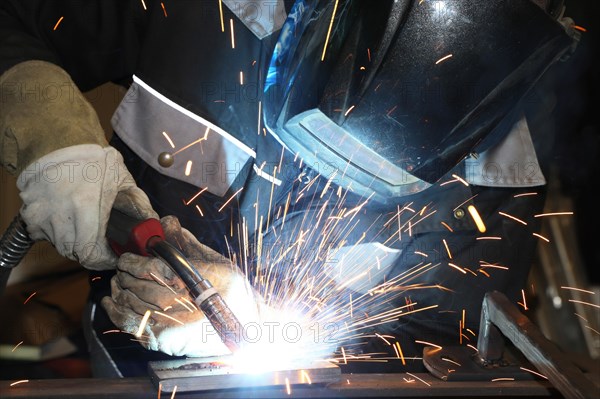 Metalworker during welding work in his workshop