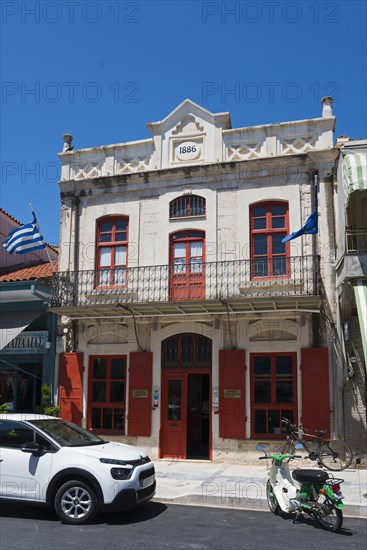 Historic neoclassical building with striking red windows and parked scooter, Museum of Silk Art, Soufli, Eastern Macedonia and Thrace, Greece, Europe