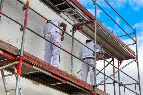 Painter painting the facade of a new residential building