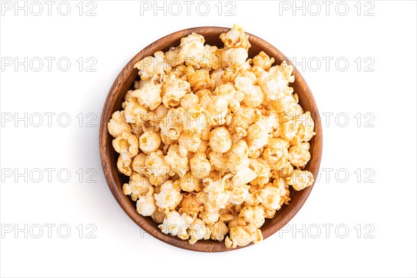 Popcorn with caramel in wooden bowl isolated on white background. Top view, flat lay, close up