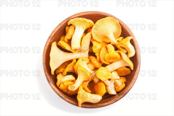 Bunch of chanterelle mushrooms in wooden bowl isolated on white background. top view, close up