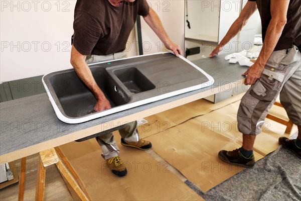 Craftsmen installing a new kitchen (kitchen assembly)