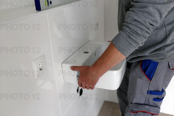 Plumber installs a new washbasin