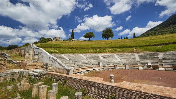 Historic theatre site with tiered rows of seats under a partly cloudy sky, Ancient Theatre, Archaeological site, Ancient Messene, Capital of Messinia, Messini, Peloponnese, Greece, Europe