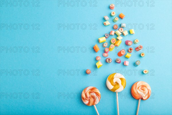 Various caramel candies on blue pastel background. copy space, top view, flat lay