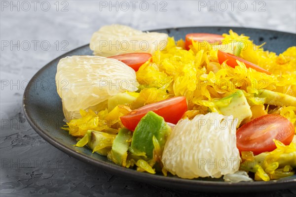 Fried pomelo with tomatoes and avocado on gray concrete background. side view, close up, myanmar food