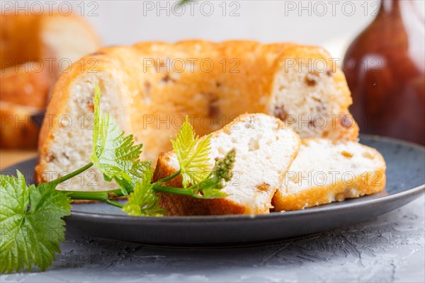 Cakes with raisins and chocolate and a cup of coffee. lilac flowers on a gray concrete background, side view