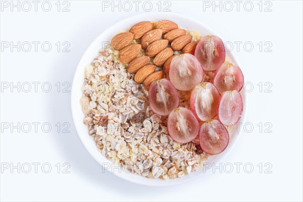 A plate with muesli, almonds, pink grapes isolated on a white background. top view