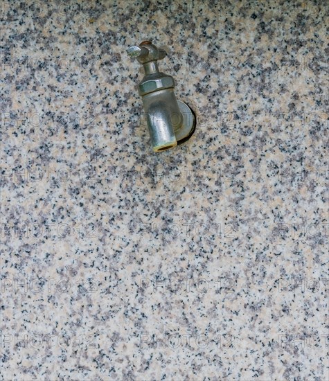 Closeup of water faucet on marble water fountain in public park in South Korea